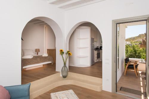 a living room with a bed and a vase of flowers at Levantes House Mykonos in Ano Mera