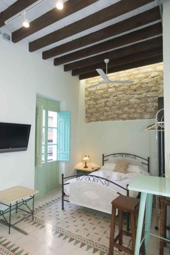 a bedroom with a bed and a stone wall at Vintage & Cosy Auditorium in Alicante