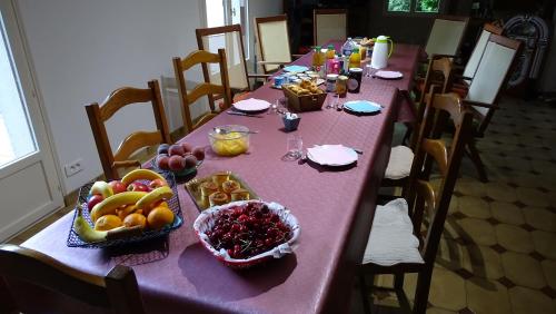 - une longue table avec de la nourriture et des fruits dans l'établissement Chambres de Monthéard, à La Bazoge