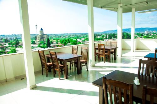 a balcony with tables and chairs and a view of the city at Hotel Grand in Zugdidi
