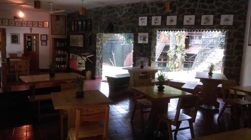a restaurant with tables and chairs and a window at Wildernest in Thekkady