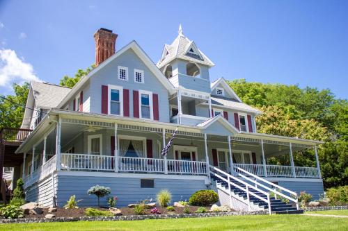 a large white house with a turret at Hudson Manor Bed & Breakfast in Watkins Glen