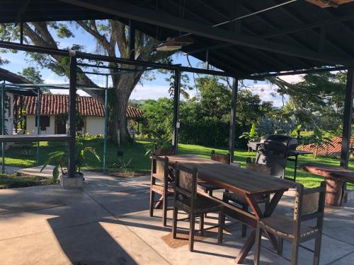 a picnic table and chairs under a pavilion with a grill at Finca Hotel Brasilia in La Tebaida