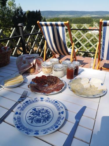 a table with plates of food on top of it at Itt és Most - Szent György-hegy in Raposka