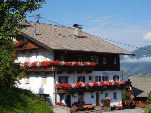 a large white building with red flowers on it at Gästehaus Maria in Kartitsch