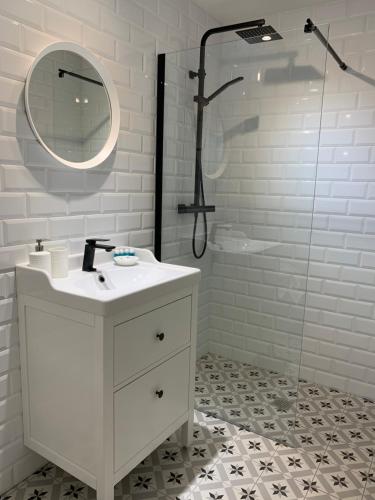 a white bathroom with a sink and a shower at Apartamento El Estanque - HA Peña Santa in Benia