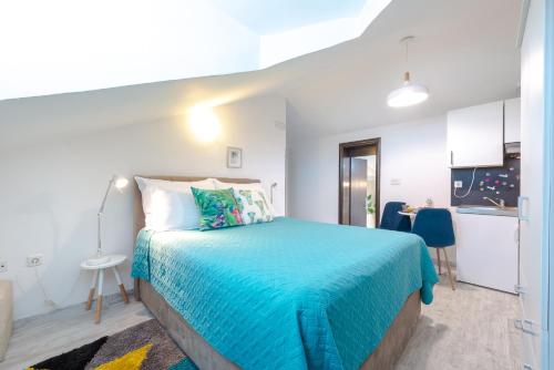 a bedroom with a large bed with a blue blanket at Apartments Grgich in Dubrovnik