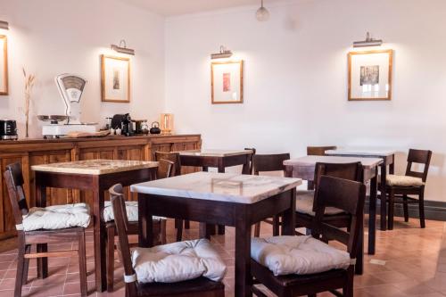 a restaurant with tables and chairs in a room at Casa do Lado in Vila Nova de Milfontes