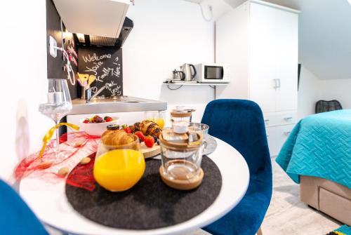 a table with breakfast foods and orange juice on it at Apartments Grgich in Dubrovnik