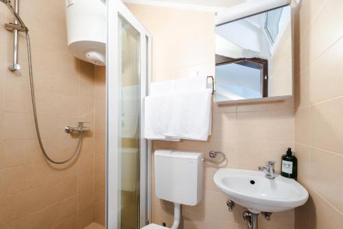 a bathroom with a sink and a toilet and a mirror at Apartments Grgich in Dubrovnik