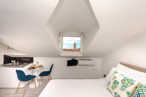 a bedroom with a bed and two blue chairs at Apartments Grgich in Dubrovnik