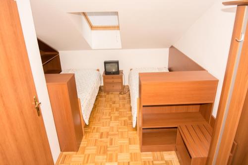 a small attic bedroom with two beds and a television at Guesthouse Jersin in Logatec