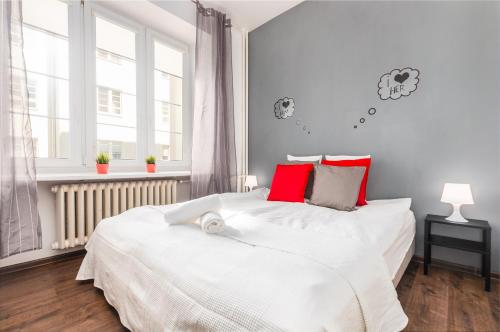 ワルシャワにあるApartments Madelaine Warsawのベッドルーム(赤い枕の大きな白いベッド付)