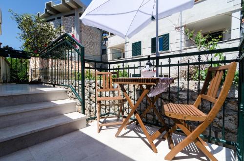 a table and two chairs and an umbrella on a patio at Apartments Grgich in Dubrovnik