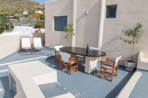 a patio with a table and chairs on a roof at Lotza Studios in Oia