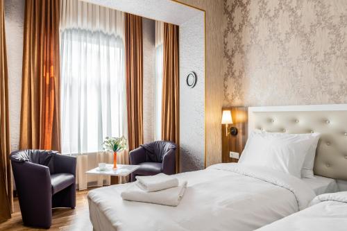 Ornament Hotel في تبليسي: غرفه فندقيه بسرير وكرسيين وطاولة