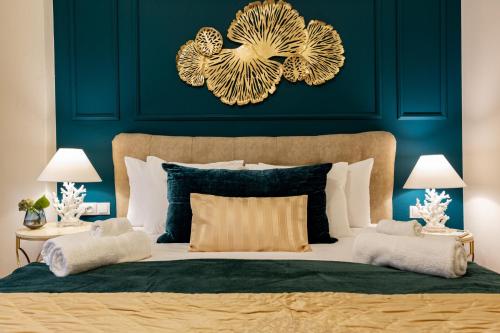 a bedroom with a large bed with blue walls and gold decorations at Emerald Oasis in Bucharest