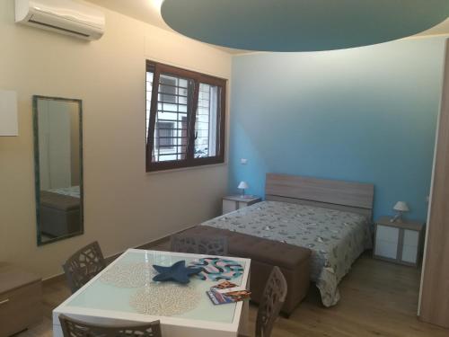 a bedroom with a bed and a table with chairs at Casa Mirtillo in Bernalda