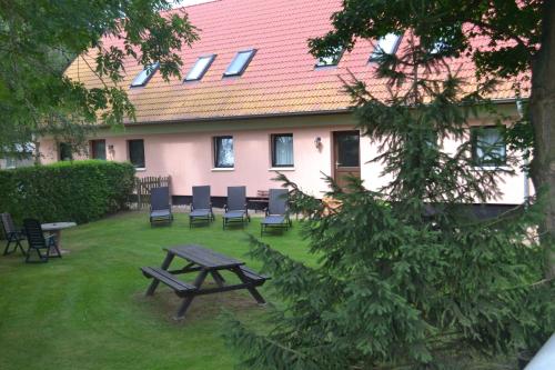 una mesa de picnic y sillas frente a un edificio en Haus Simone, en Poel