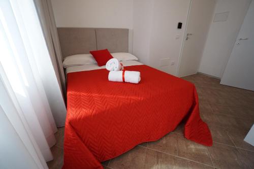 a bedroom with a red bed with two towels on it at Terra di Negroamaro in Leverano