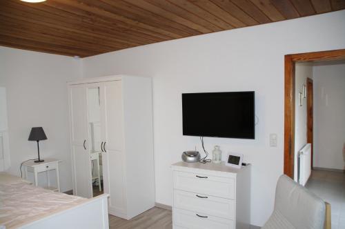 a bedroom with a bed and a flat screen tv at Bungalow am Forsthaus Stagnieß in Ueckeritz