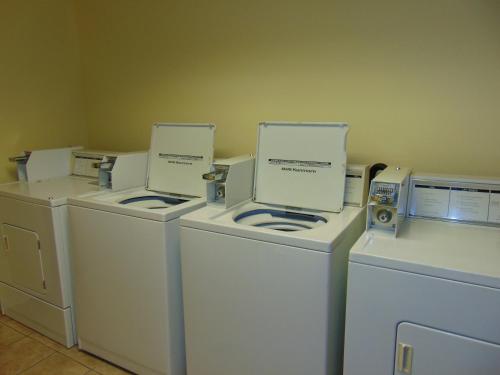 a group of four washers and dryers in a room at Horse Creek Inn in McCook