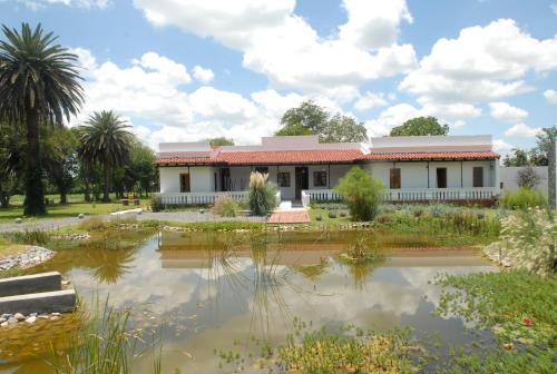 a house with a pond in front of it at Hotel Cerros in Rosario de Lerma