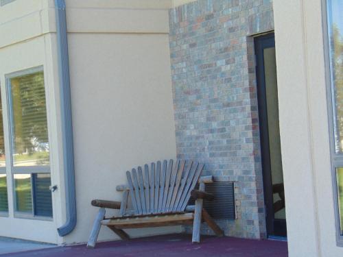 a wooden rocking chair sitting outside of a building at Horse Creek Inn in McCook