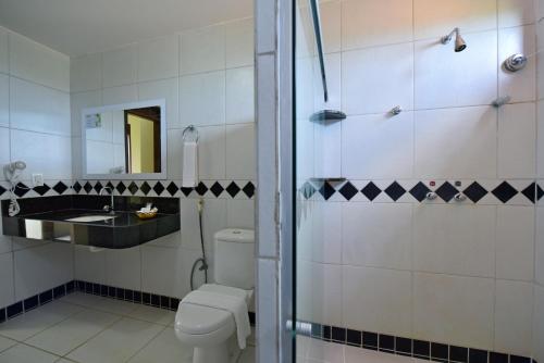 La salle de bains est pourvue de toilettes et d'un lavabo. dans l'établissement Aruanã Pousada, à Jacumã