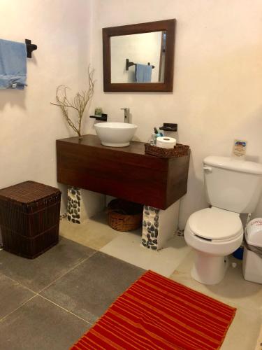 a bathroom with a white toilet and a sink at Ch'ejum bungalow in Cancún