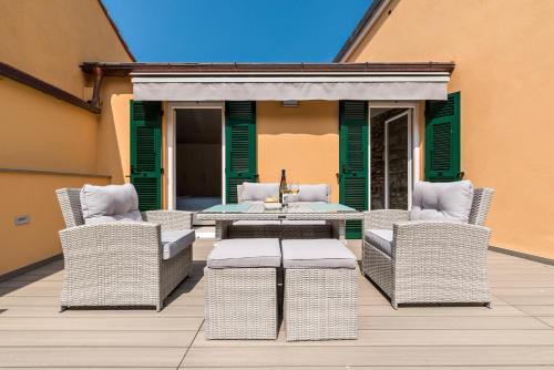 a patio with wicker chairs and a table on a deck at Amanarola in Manarola