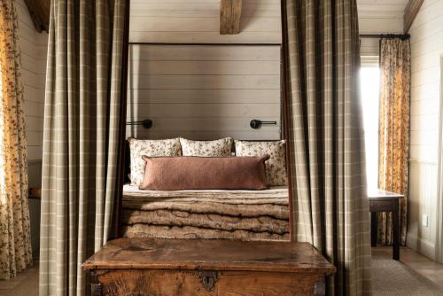 a bed in a room with curtains and a wooden table at Eleven Scarp Ridge Lodge in Crested Butte