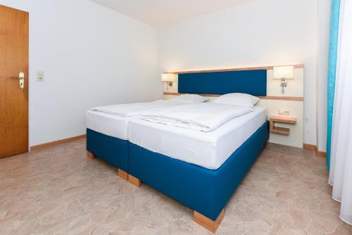 a bed in a room with a blue and white bed at Haus Hafeneck mit Frühstücksoption in Bensersiel