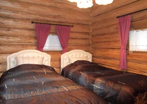two beds in a log cabin with windows at Kameda-gun - Cottage / Vacation STAY 34923 in Nanae
