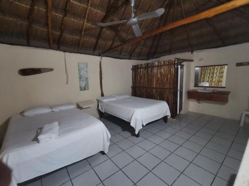 een slaapkamer met 2 bedden en een plafond bij Las Cabañas del Doctor in Mahahual