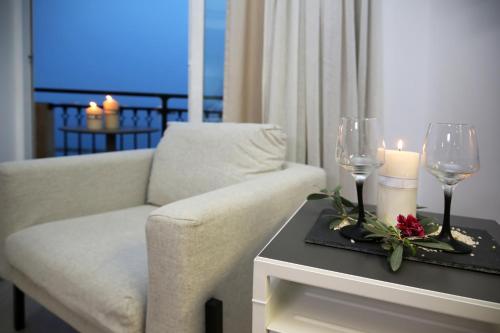 a living room with a white couch and a table with candles at Pier Beach Hotel Apartments in Limassol