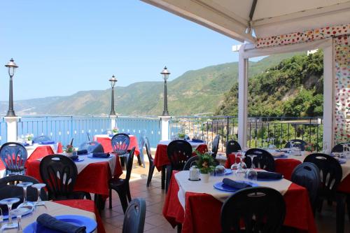 un restaurante con mesas y sillas con una montaña en el fondo en seaside room, en Scilla