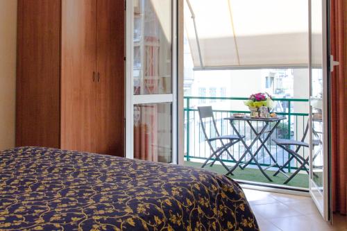 a bedroom with a bed and a balcony with a table at Casa Vacanze Isophylla in Finale Ligure