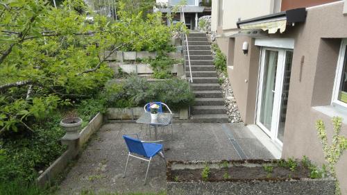 uma cadeira azul sentada num quintal ao lado de uma escada em Chill and Adventure em Ersigen