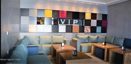 a living room with a couch and tables and a painting at Honor Appart Hotel in Fnidek