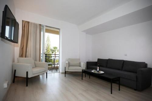 a living room with a couch and a table and chairs at Pier Beach Hotel Apartments in Limassol