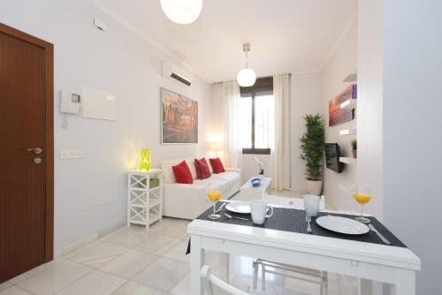 a kitchen and living room with a couch and a table at The Zentral Suites & Apartments in Seville
