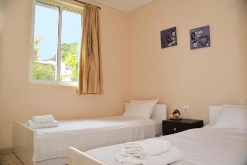 twee bedden in een kamer met een raam bij Sarakiniko villa with private pool in Póros