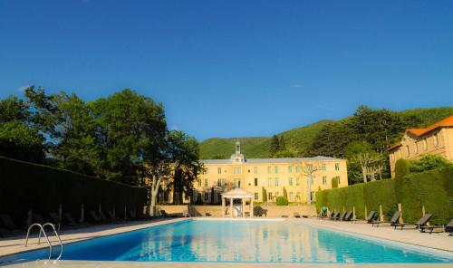 a large swimming pool in front of a building at Chateau des Gipières bij de Mont Ventoux in Montbrun-les-Bains