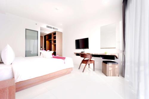 a white bedroom with two beds and a desk at Phoenix Hotel Karon Beach in Karon Beach