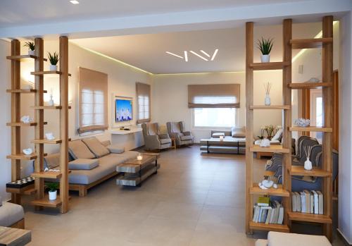 a living room with a couch and chairs and shelves at Aeolos Resort in Mýkonos City