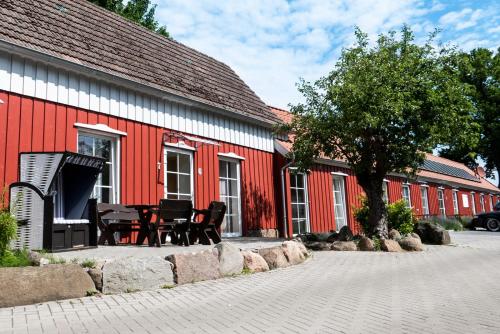 a table and chairs in front of a red building at Gästezimmer am alten Kaffee Hof in Suderburg