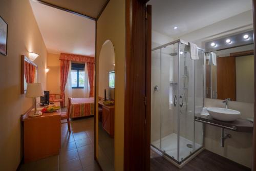 a bathroom with a glass shower and a sink at TH Cinisi - Florio Park Hotel in Cinisi