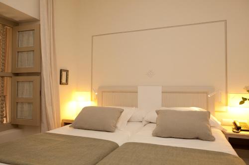a bedroom with a large white bed with two pillows at Balcón de Córdoba in Córdoba