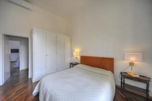 a white bedroom with a bed and two night stands at Rome Luxury House - The House in Rome